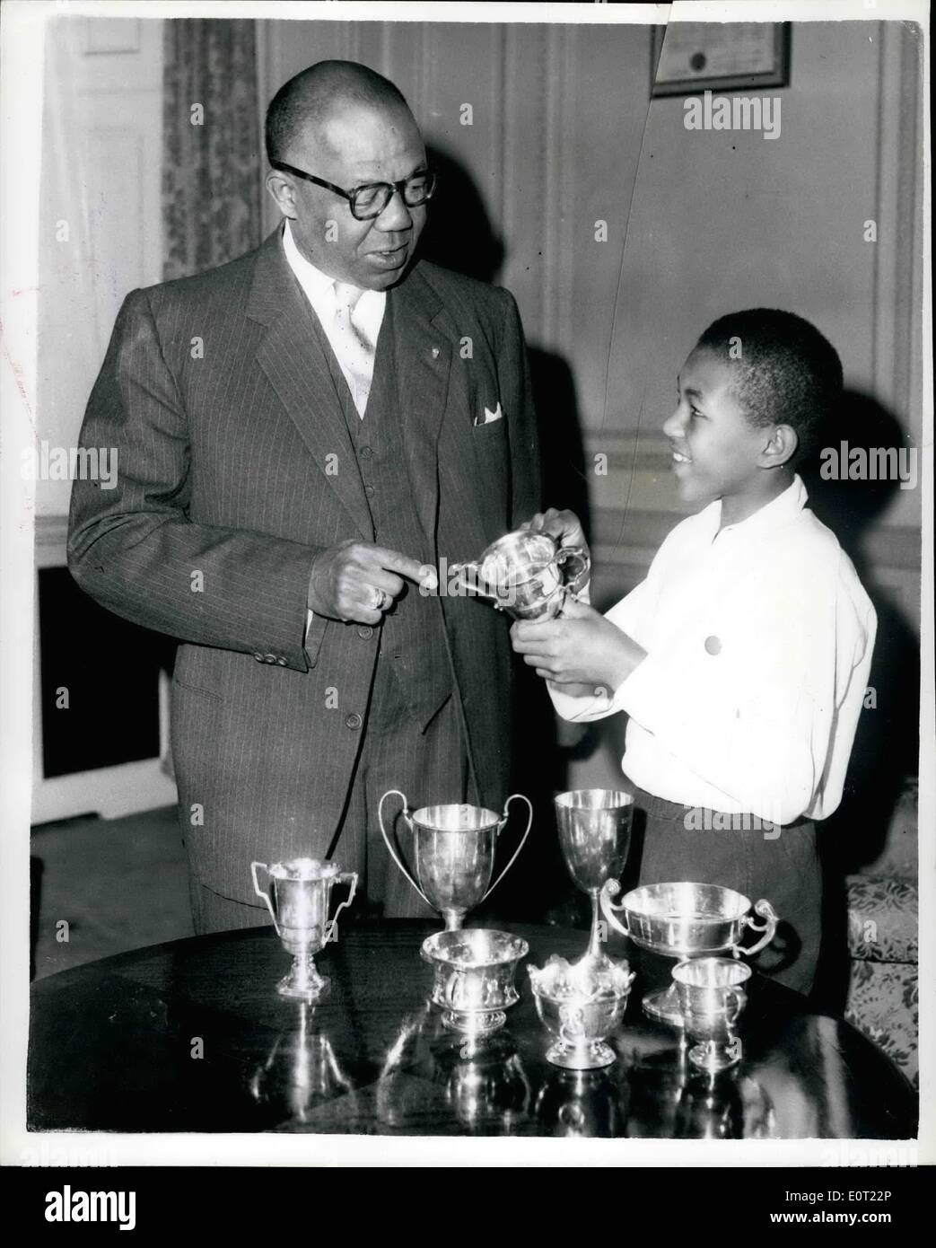 Jul. 07, 1960 - The Athletic son of the Liberian Ambassador to London wins eight cups in one sports meeting: George Brewer (Jnr) - 11year old son of George T. Brewer the Liberian Ambassador to London - took part in his School Sports - Zaton House School, Belagravis - last Thursday - and came away with no fewer that eight silver cups - winning them in the following events --- 80 yards; 100 yards; 330 yards; 220 yards; High Jump; Long Jump; House Relay and the 'Victor Ludurum' cup for the best all round sportsmen. Photo shows George T. Brewer the Ambassador and his athletic son - George Jnr Stock Photo