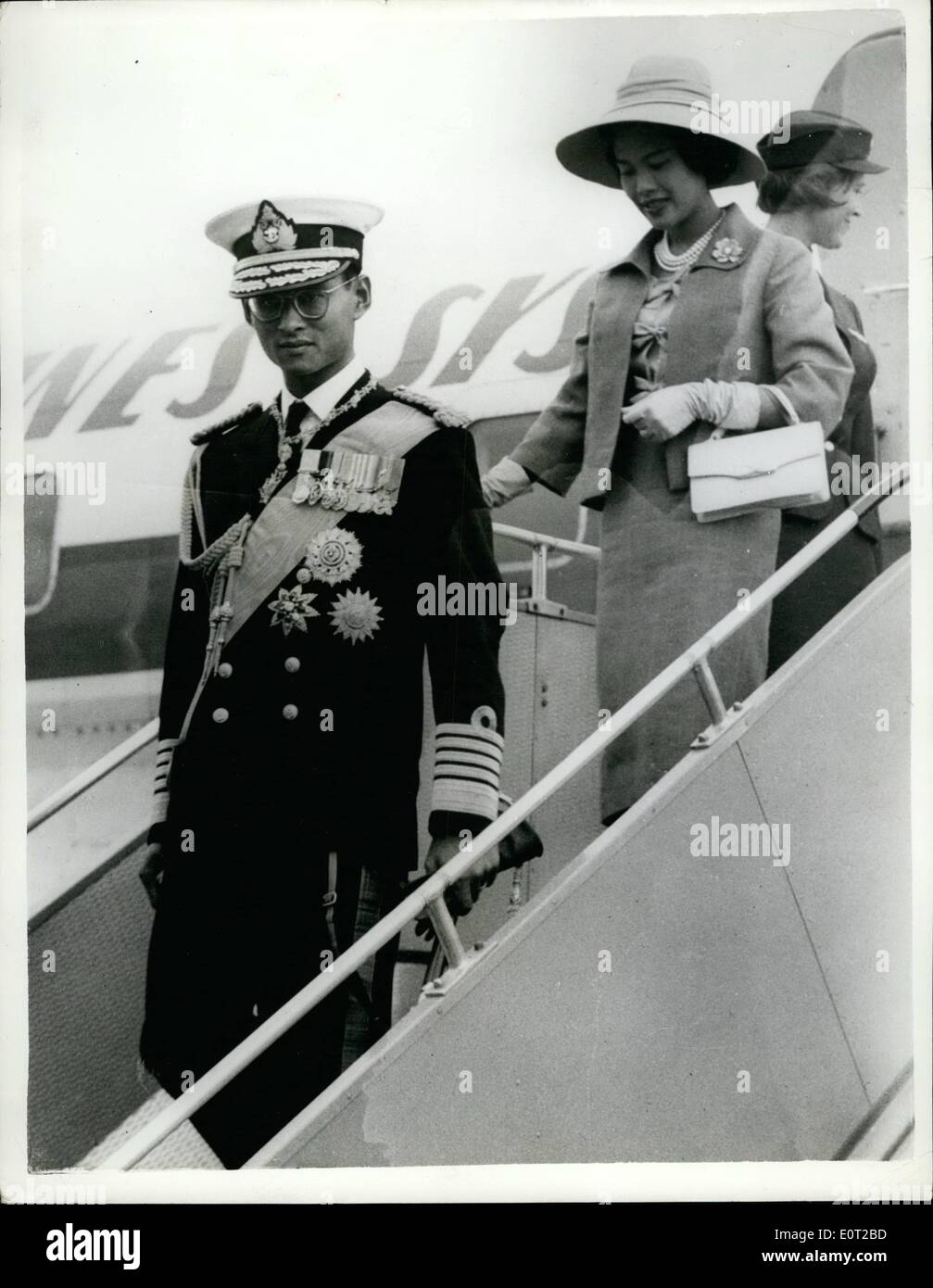 Jul. 07, 1960 - King and Queen of Thailand arrive for state visit: King Phumipol of Thailand, wearing naval uniform, and Queen Sirikit, in a mauve suit, pictured leaving the aircraft on arrival at Gatwick Airport from Geneva today, for a three day State visit to Britain. They traveled from the airport by train to London, where they were welcomed by the Queen and Prince Philip. Stock Photo