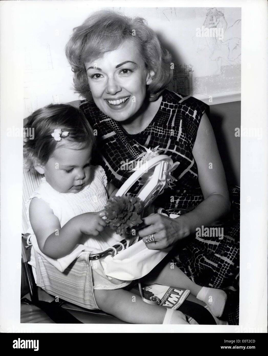 Jul. 08, 1960 - N.Y. International Airport, July 8, 1960--Lovely Edie Adams Kovacs playfully amuses her one year old daughter Mia Prior to winging their way via Twa's superjet to their home in Los Angeles. Miss Adams who has been in town for two weeks, says that she and her husband will leave shortly for Europe to work on Ernie Kovac's new movie. Stock Photo