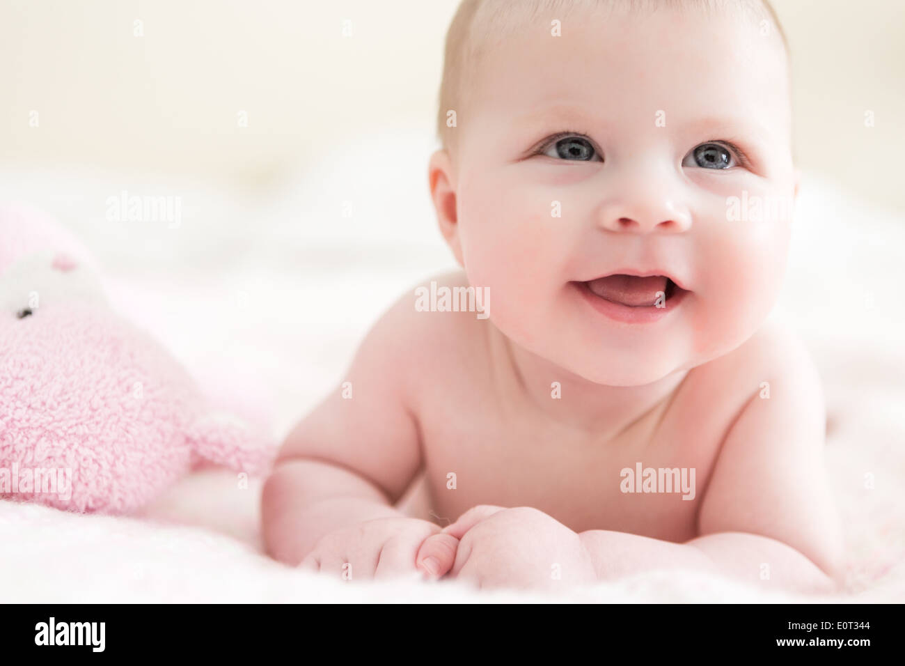 Infant baby girl playing on a pink blanket Stock Photo - Alamy