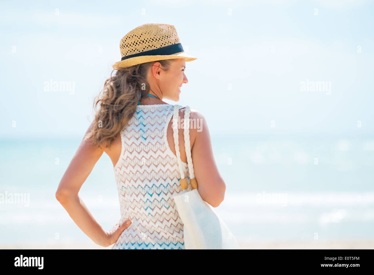 Happy young woman in hat on beach looking into distance Stock Photo - Alamy
