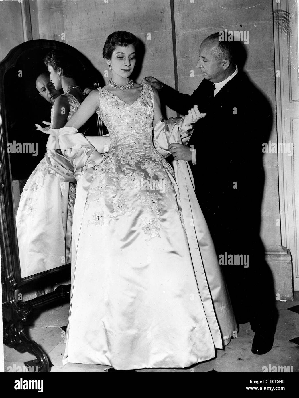 Fashion designer Christian Dior fitting a woman's gown Stock Photo