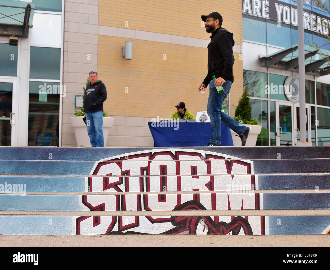 Pedestrians pass a Guelph storm sign drawn on the steps outside the