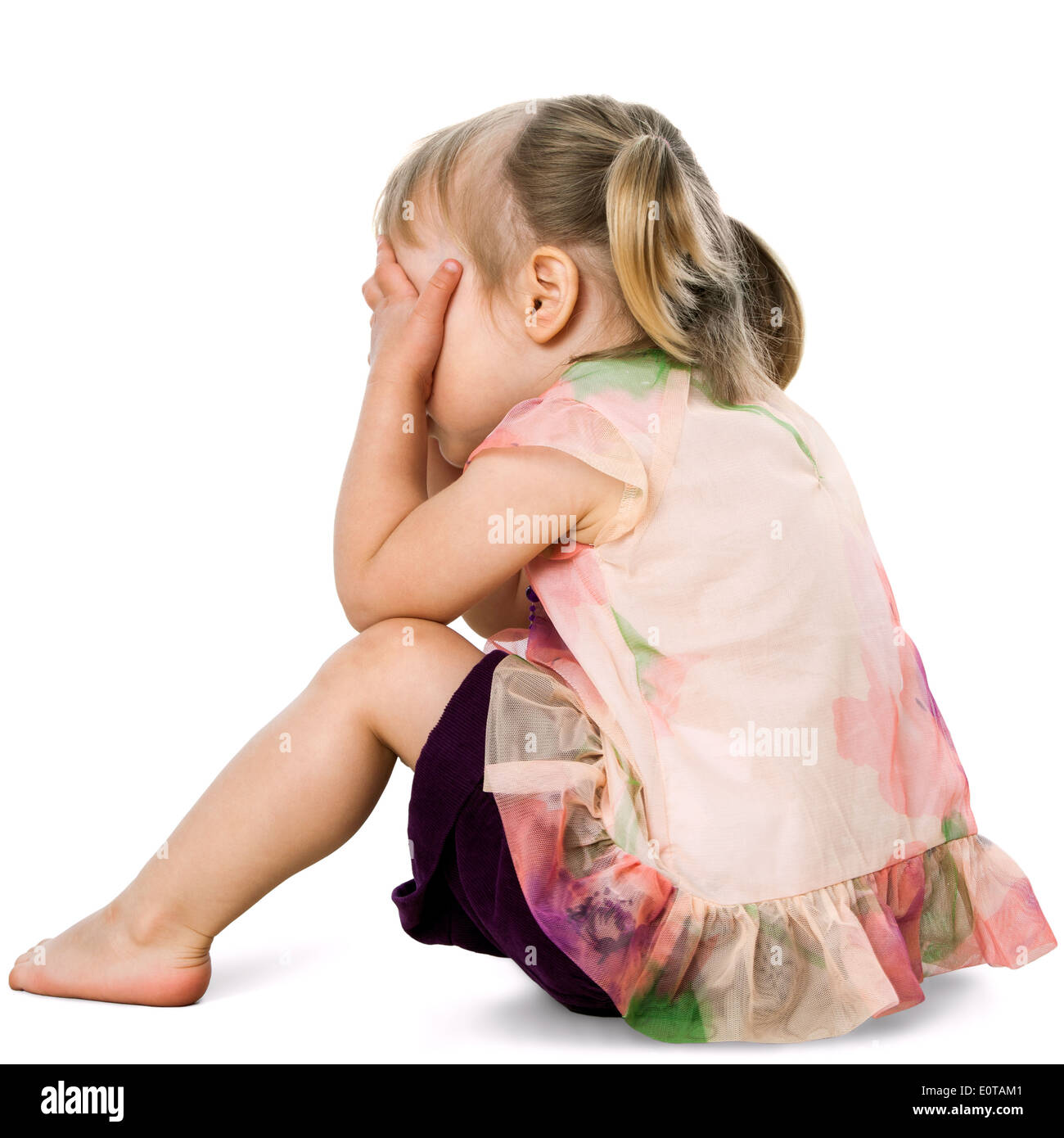 Portrait of upset little girl hiding face behind hands.Isolated on white. Stock Photo