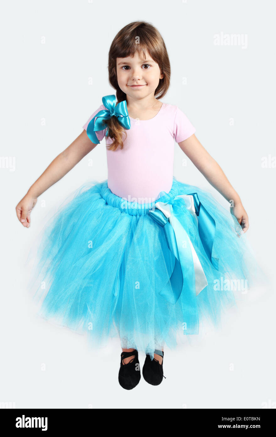Little Girl Performing in Tutu Skirt Studio Shot over Grey Stock Photo