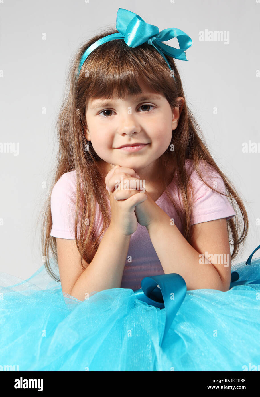 Little Smiling Girl Sitting Hands Together Studio Shot Stock Photo