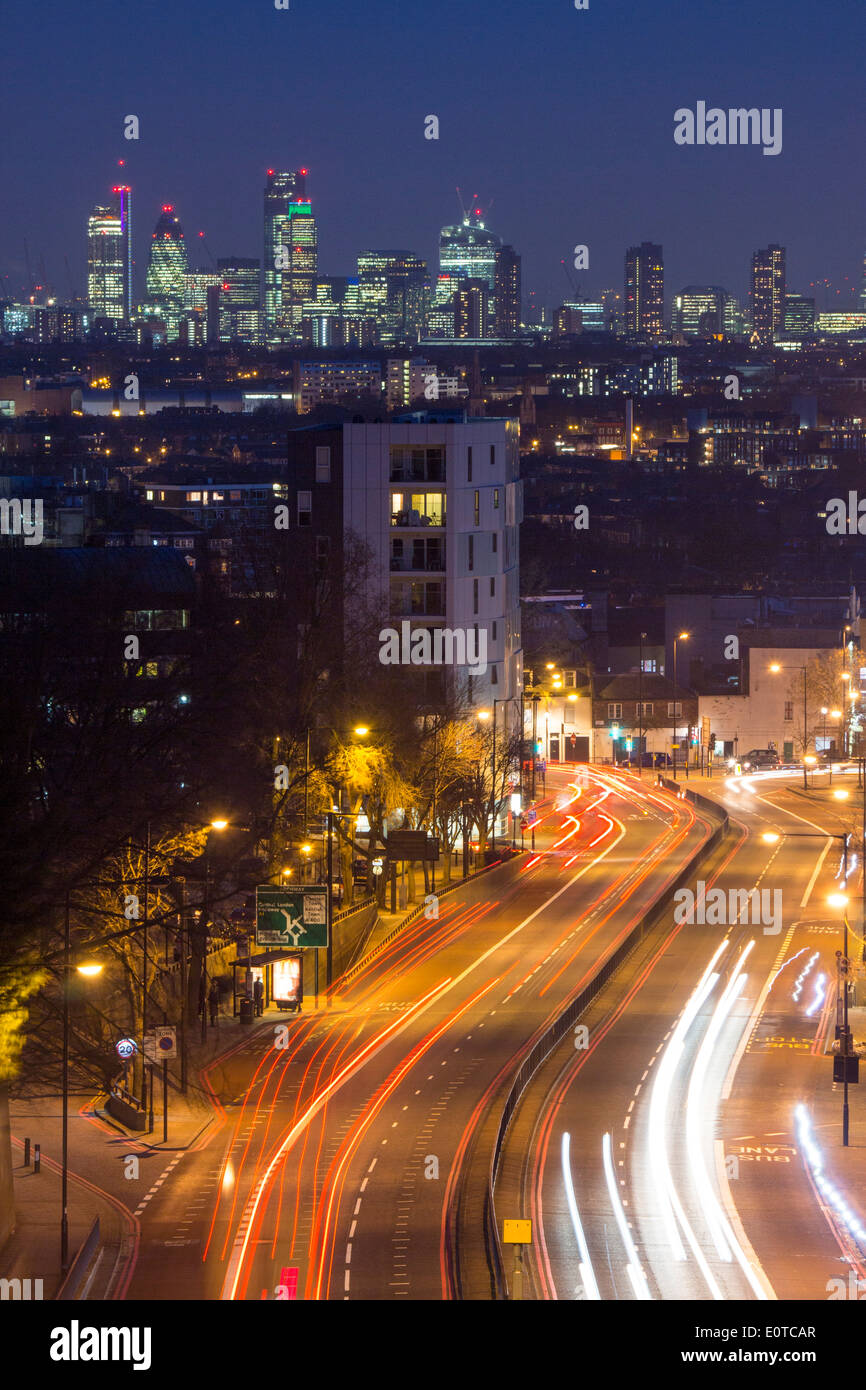 View from Archway bridge to London City skyline and Shard at night with traffic trails on road in foreground London England UK Stock Photo