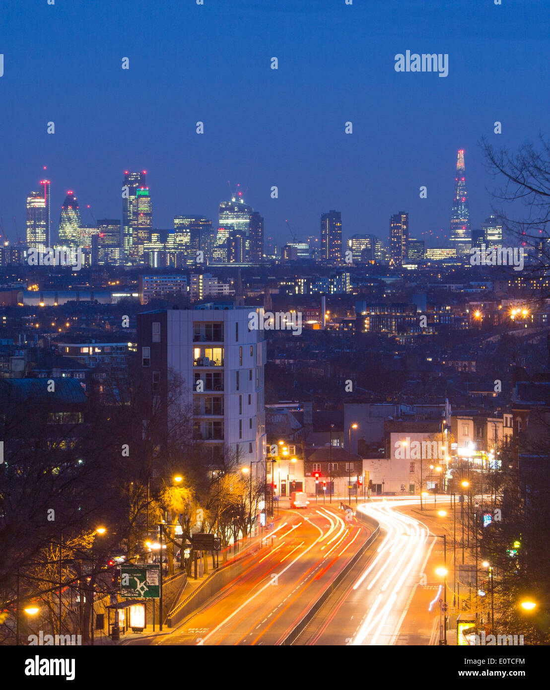 View from Archway bridge to London City skyline and Shard at night with traffic trails on road in foreground London England UK Stock Photo