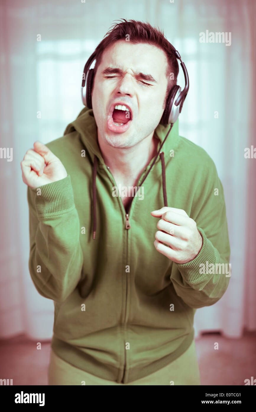 Crazy casual young man with headphones singing. Stock Photo