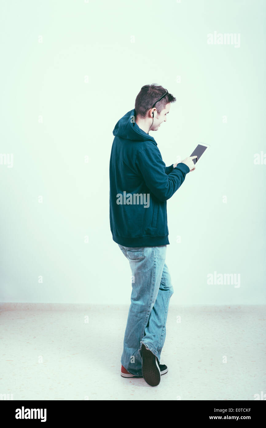 Young man in hoodie using digital tablet. Stock Photo
