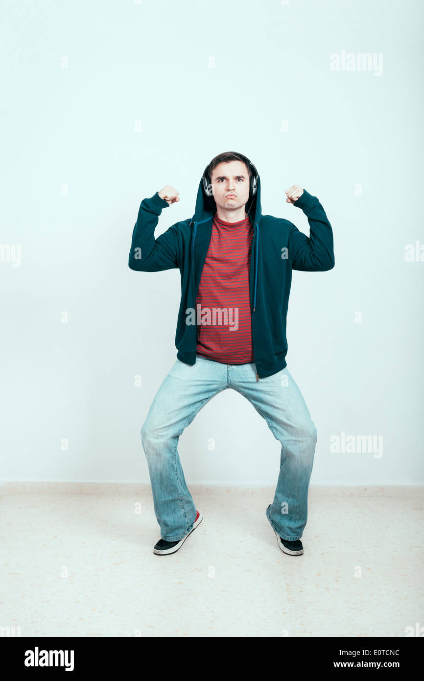 Self-confident man in hoodie with headphones showing his power. Stock Photo