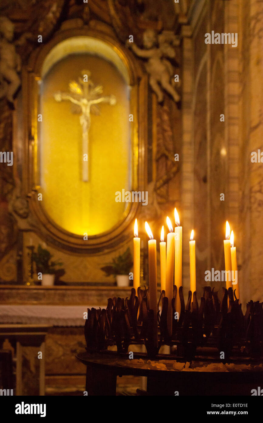 Candles in front of Jesus Christ on the Cross, religious symbols of