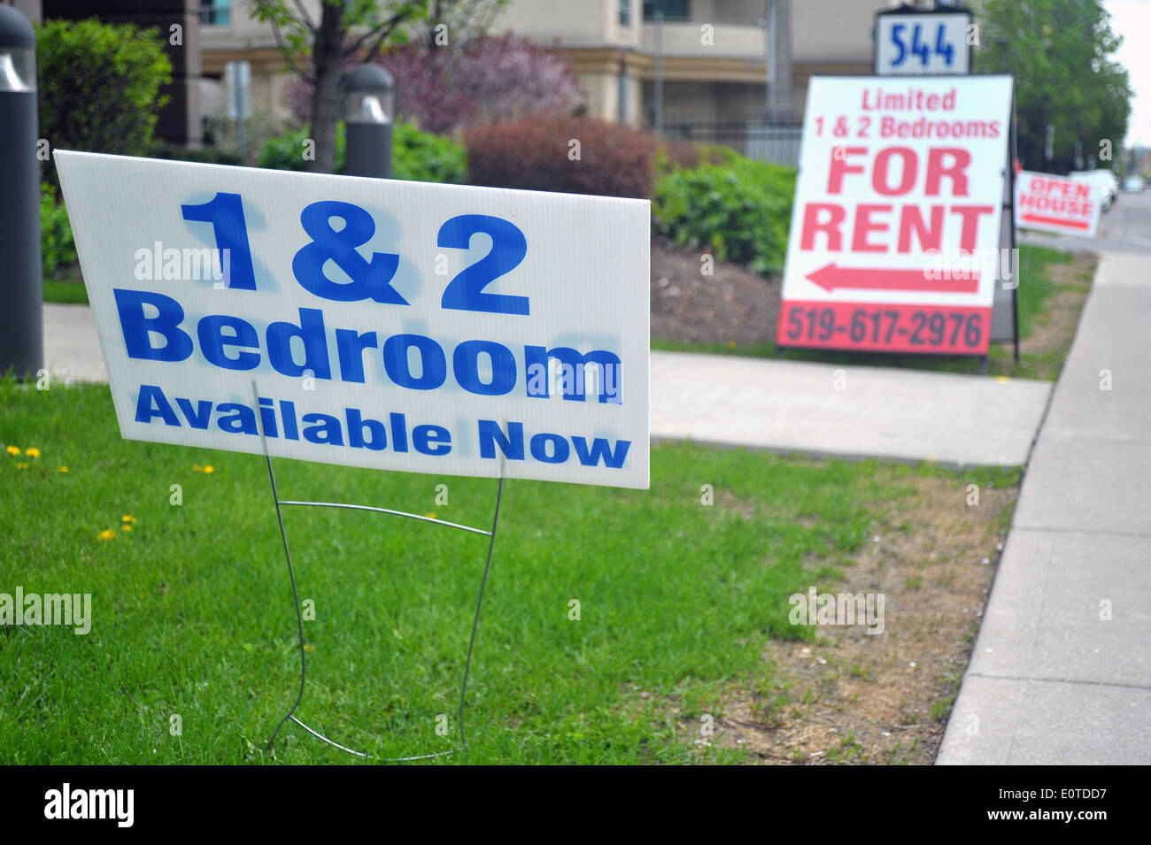Renting and open house signs on the side of the pavement. Stock Photo