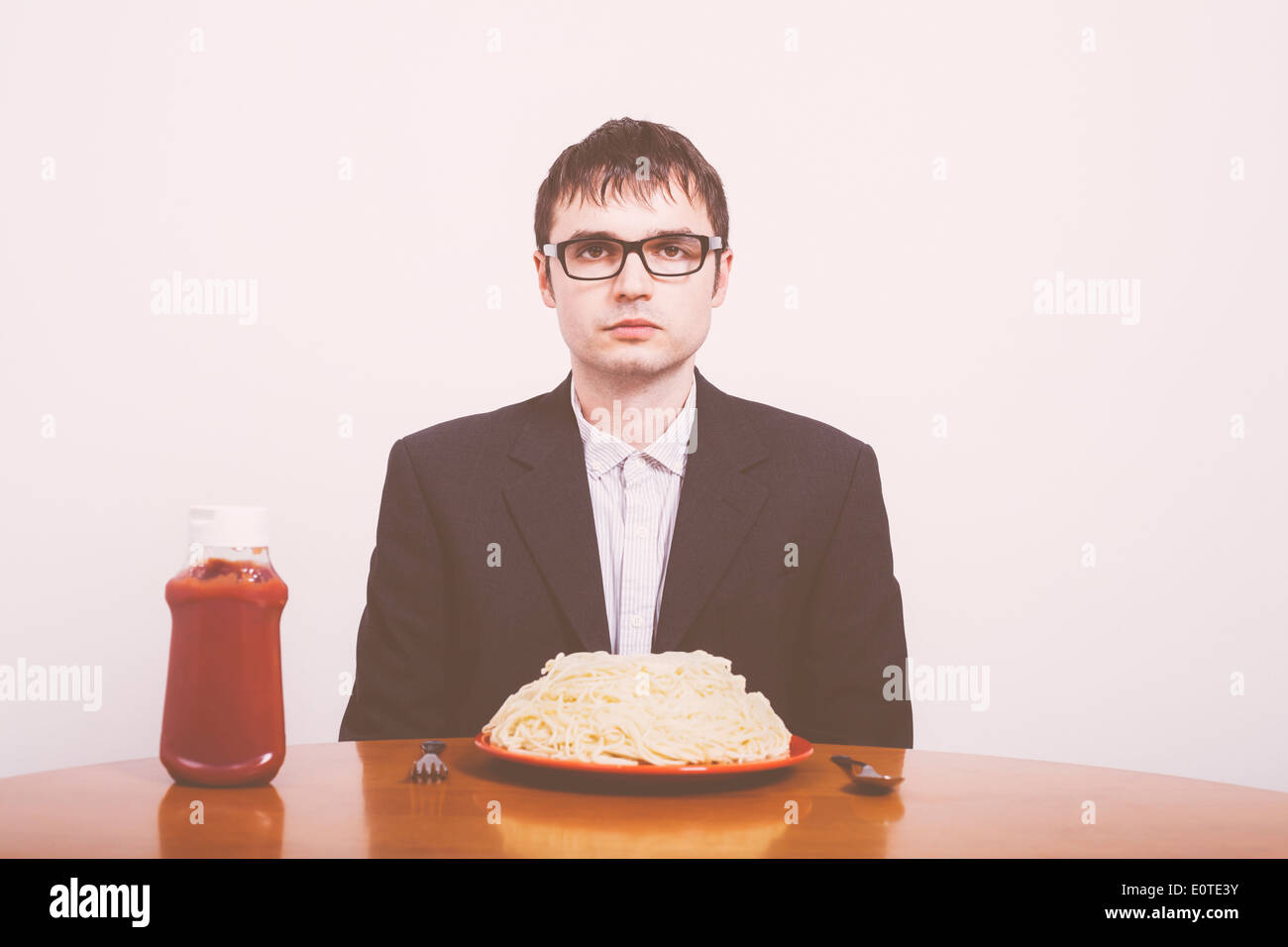 Serious businessman and pasta with ketchup on the table Stock Photo Alamy