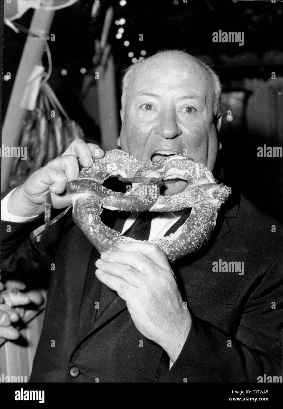 Film maker Alfred Hitchcock eats a giant pretzel at October Fest Stock Photo