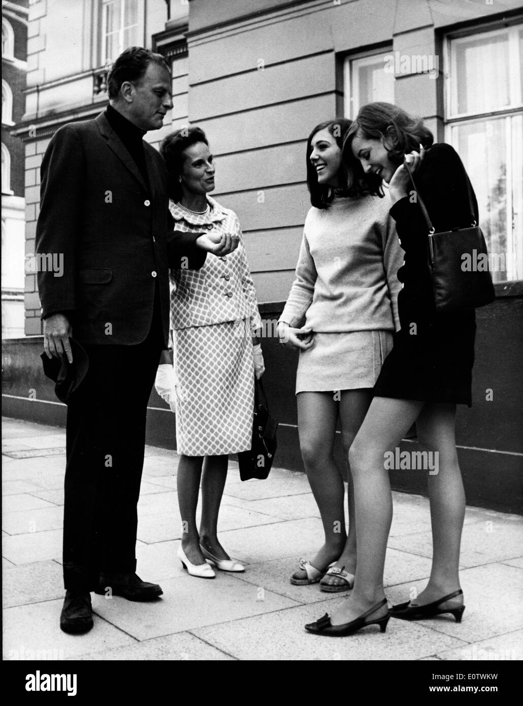 Reverend Billy Graham chats with ladies on sidewalk Stock Photo