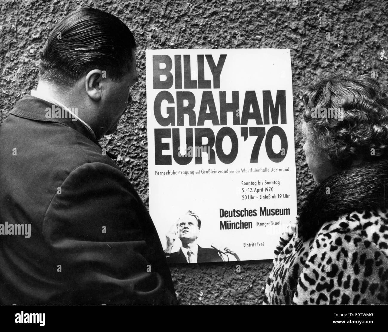 Civilians read Billy Graham tour poster Stock Photo