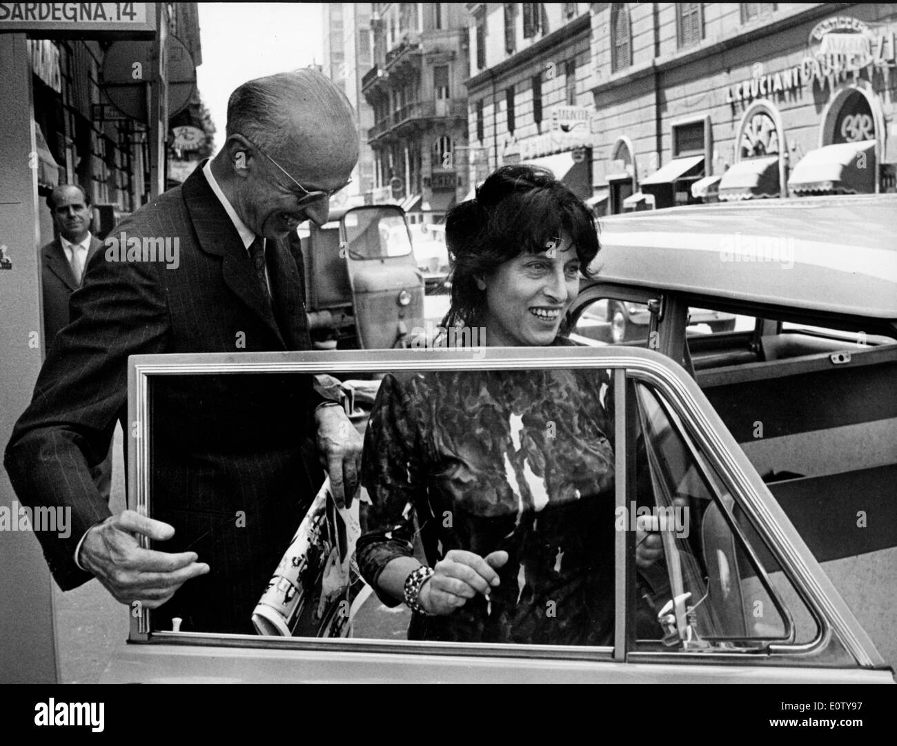 Actress Anna Magnani gets in car with Ercole Graziadei Stock Photo