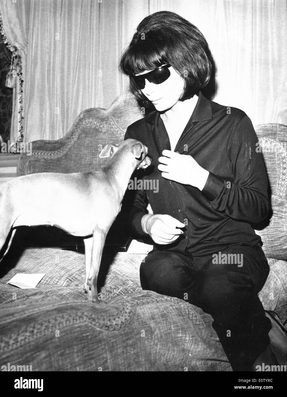 Juliette Greco sitting on the bed with her dog Stock Photo