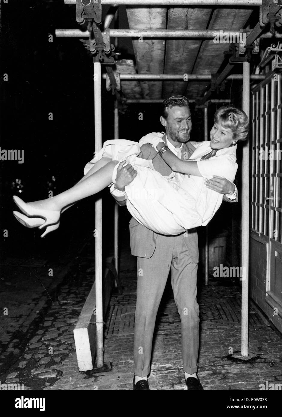 Actor Laurence Harvey carrying a woman Stock Photo