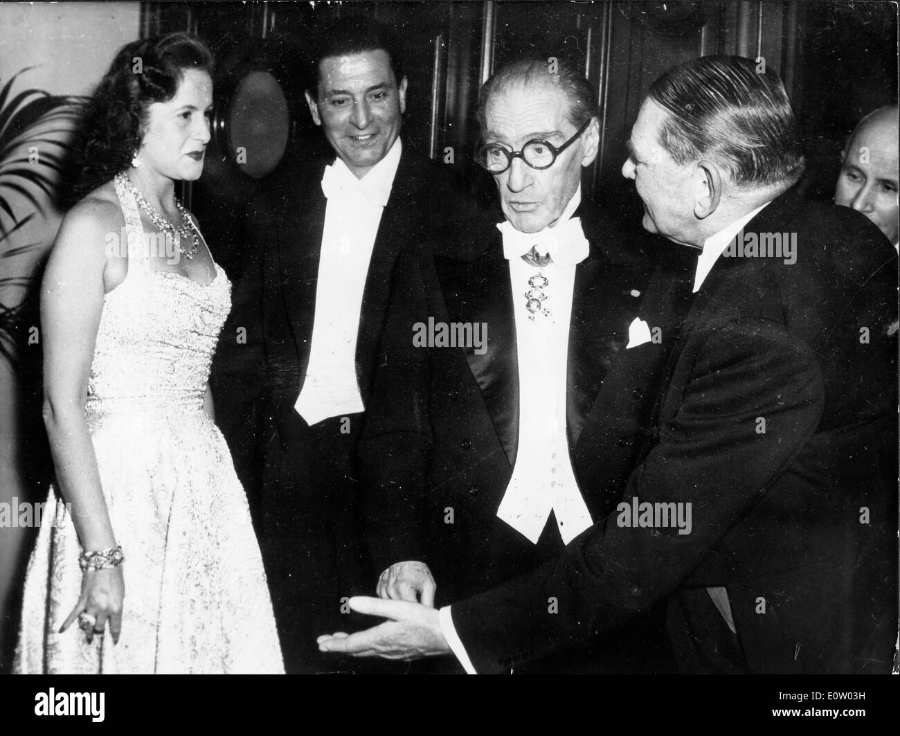 Actor Sacha Guitry talks with friends at a party Stock Photo