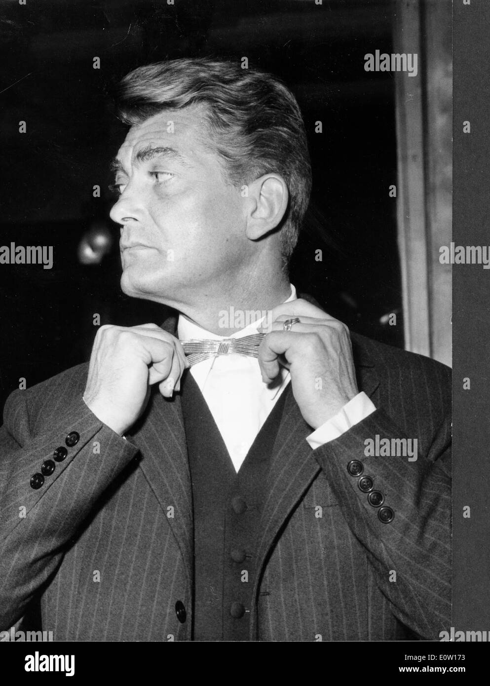 Actor Jean Marais straightening his tie Stock Photo