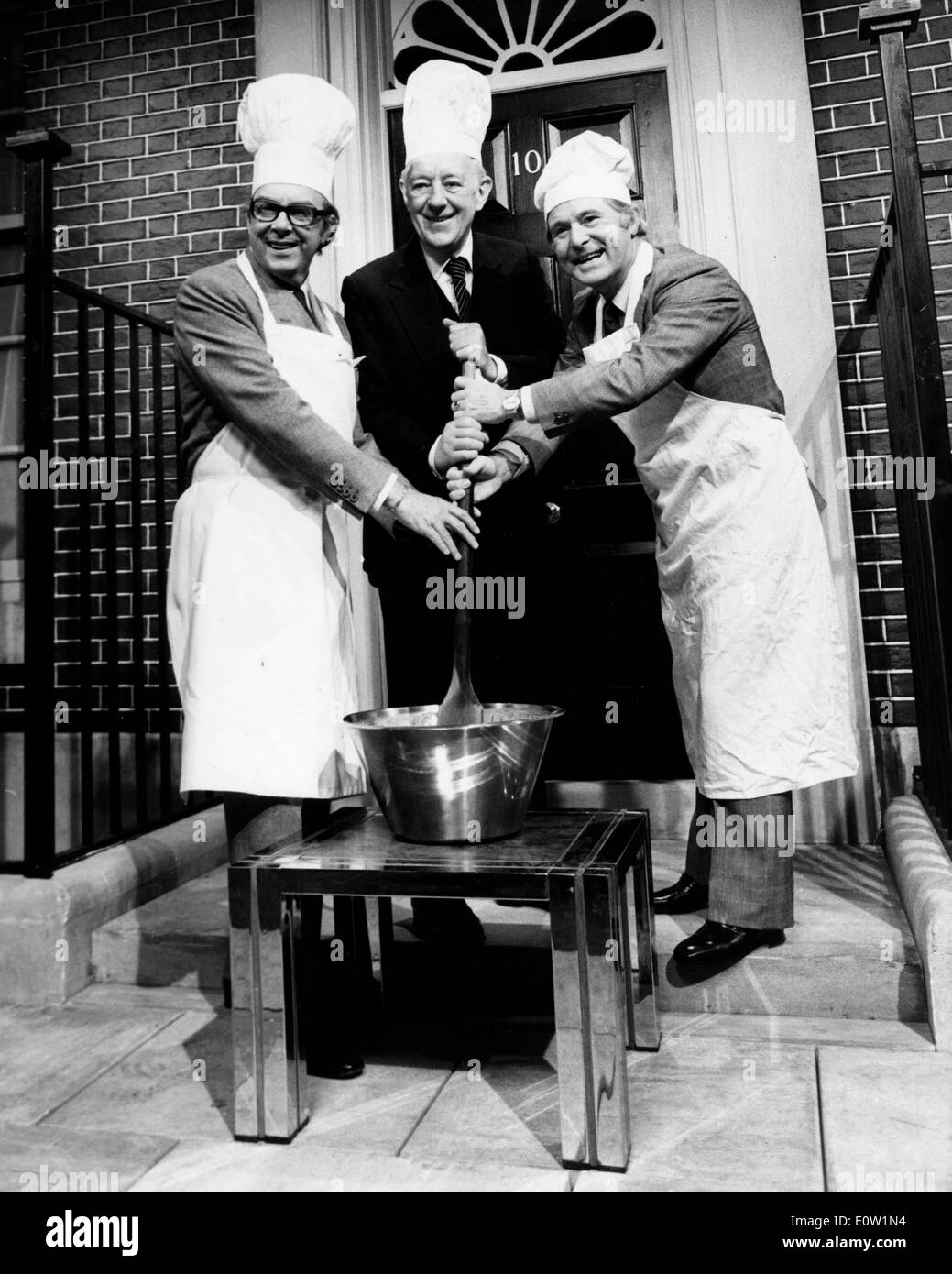 Actor Alec Guinness cooking outside No. 10 Downing Stock Photo