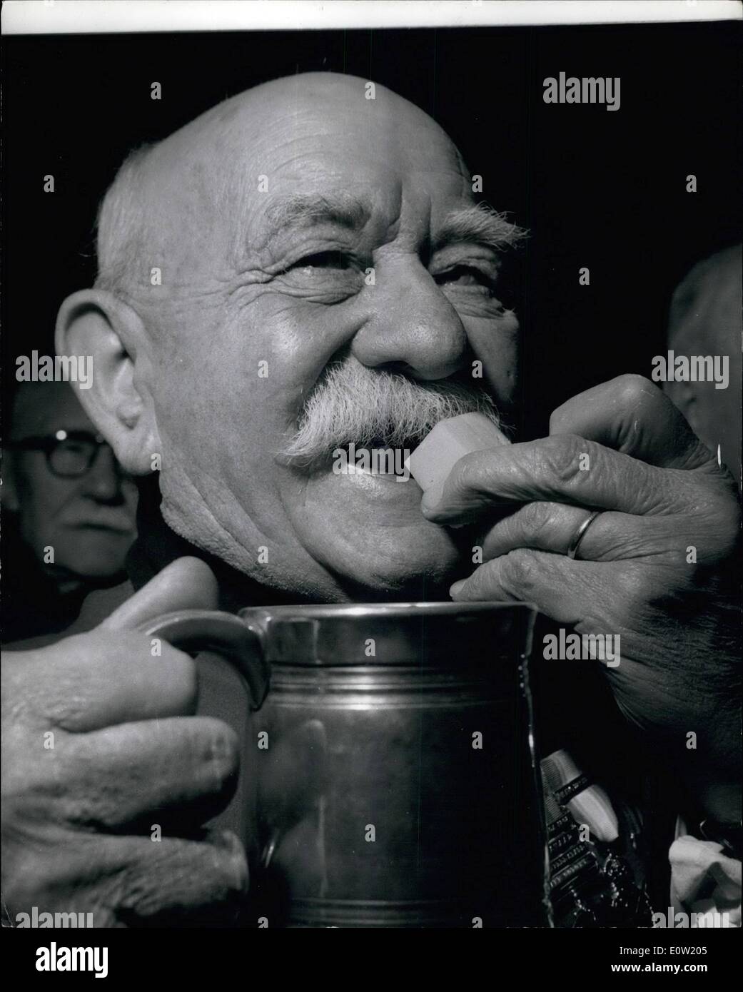 Dec. 12, 1960 - Cheers with Cheese Ancient ceremony at Royal Hospital - Chelsea: The ceremony of the Christmas Cheeses'' was held yesterday at the Royal Hospital, Chelsea at which nine large cheeses were cut up and distributed to the Chelsea Pensioners - in honour of a 17th Century cheesemonger whose name has long since been forgotten but who supplied cheese to Londoners at 3d. per Lb. in 1691. Photo shows Seventy nine year old Colour Sgt. Jim Wood of Cheshire tucking into a portion of Cheese and ale at the Royal Hospital Chelsea yesterday. Stock Photo