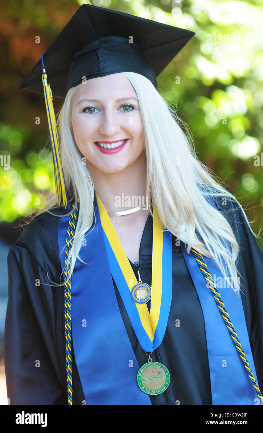Blond female U.C,. Berkeley graduate in cap and gown with honors cord and metal Stock Photo
