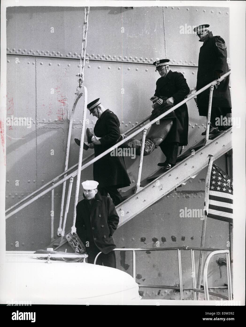 Mar. 03, 1961 - Demonstrators Squats On Nuclear Sub's Tailfin.. An anti - Polaris demonstrator sat above the waves on the tailfin of America's nuclear submarine ''Patrick Keary'' - for 45 minutes yesterday - in the Holy Lh. He stayed there until removed by police.. He was one of three ''commandos'' who want aboard the vessel - two of them were hauled up the side - and then went into their passive resistance'' drill - and the other sat on the tailfin. Photo Shows: One of the ''commandos'' - is carried off - after the demonstration - in the Holy Loh yesterday. Stock Photo