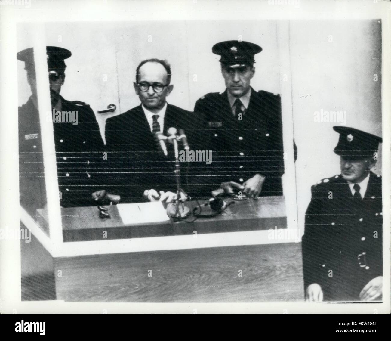 Apr. 04, 1961 - Opening of the Adolf Eichmann trail - in Jerusalem. chanced with mass murder of the Jews. The trial opened the morning in Jerusalem of Adolf elchmanh- former Nazi s.s.colonel - on charges of the Mann murder of millions of Jews in concentration campe during the war. photo shows Well guarded with a policeman on either side of home - Adolf Eichmann seen in his special bullet proof dook - at the opening of his trial in Jerusalem this morning. Stock Photo