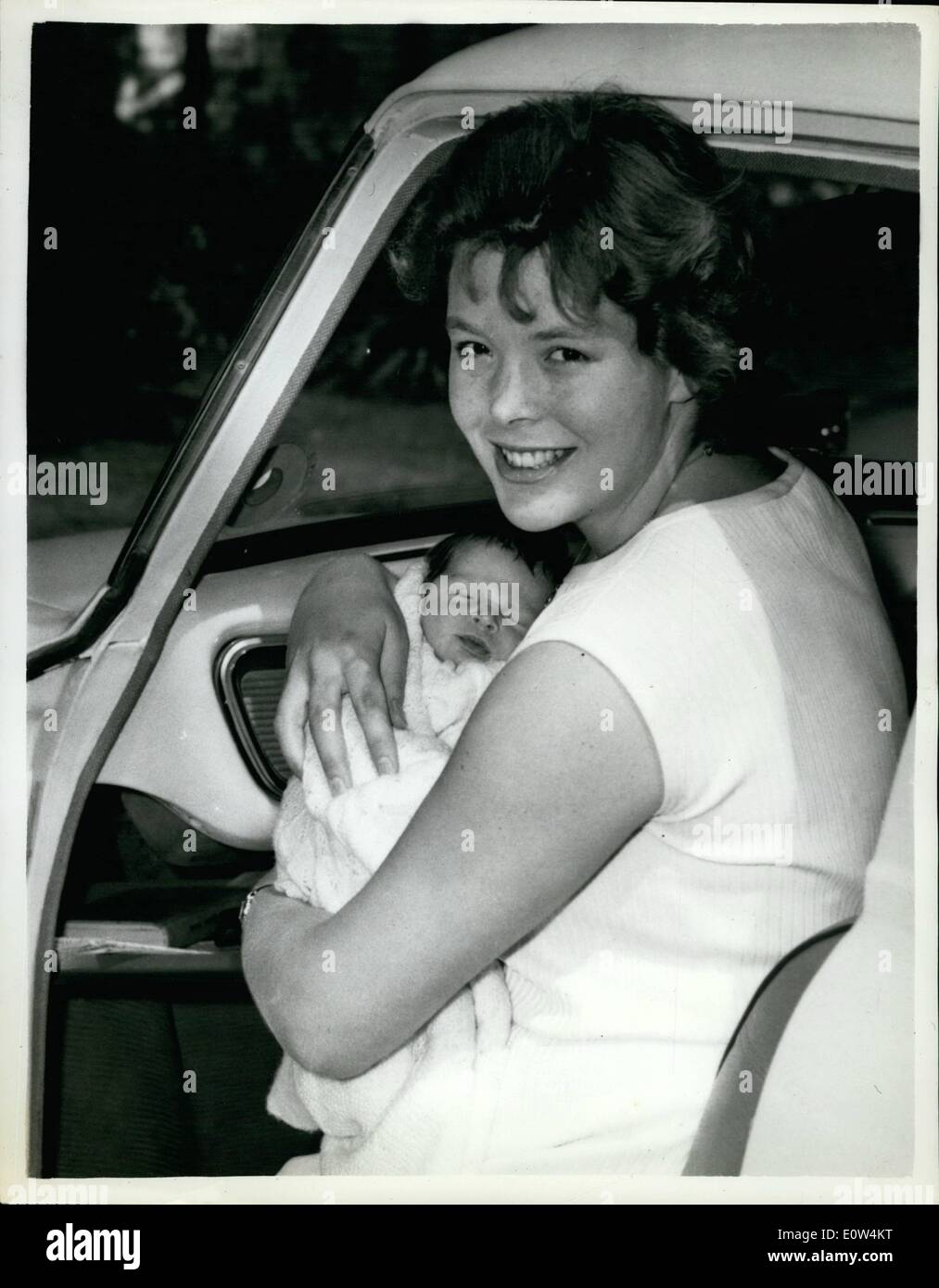 Jun. 06, 1961 - A son for Judy Grinham: Olympic swimmer, Judy Grinham, wife of sportswriter Pat Rowley, gave birth to a son in St. Mary Abbot's Hospital, Kensington, 12 days age. Today she left hospital with her baby named Keith Andrew Phillips. Photo shows carrying her baby , Judy Grinham sits sits down in the car for the drive back to her Lea gardens, Wembley, home. Stock Photo