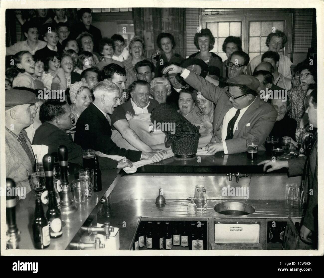 Aug. 08, 1961 - Secombe ''Knocks Down'' Pennies For Charity: Comedian Harry Secombe his morning paid a visit to the Brighton Public house in the Old Kent Road, London, to push over a pile of pennies which did been collected by the pub's regulars for the Spastics' Fund: Photo Shows Surrounded by regulars of the pub, Harry Secombe knocks over the pile of pennies at noon today - today there was about 0 worth. Stock Photo