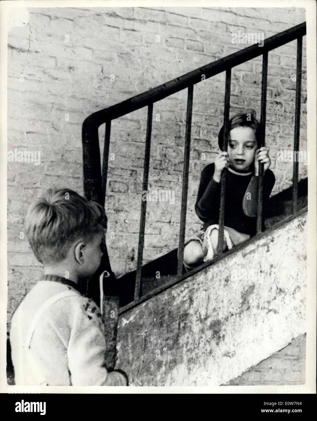 Oct. 27, 1961 - Their door to happiness: Twenty-four children from the bleak and their life of German refugees camps cometo English homes for a 10-week goliday in Lewham, Sevencake and Luton. The visit is organized by International Help for Children - which since 1947, has given holidays to more than 12,000 children.Photo shows Rosemarie Senf - one of the lucky ones chosen for a holiday. She spreads the good news in the obly playground she knows - a stairway to Spandau Camp, Berlin. The camp has always been her home. She lives there in one room with her mother, father and six other children Stock Photo