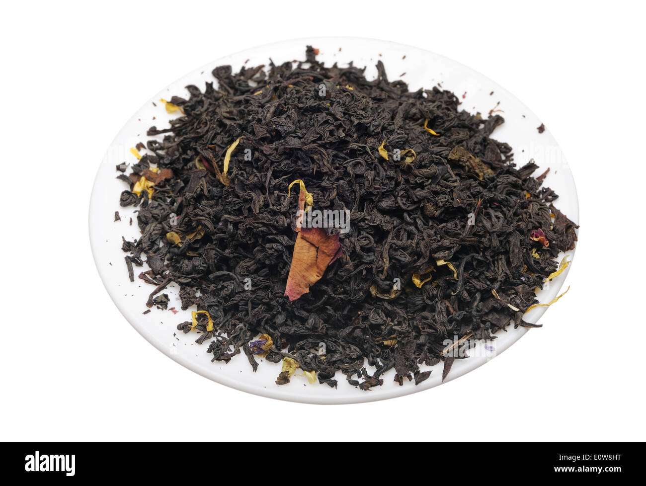 Black tea with flower petals and spices on a white background. Stock Photo