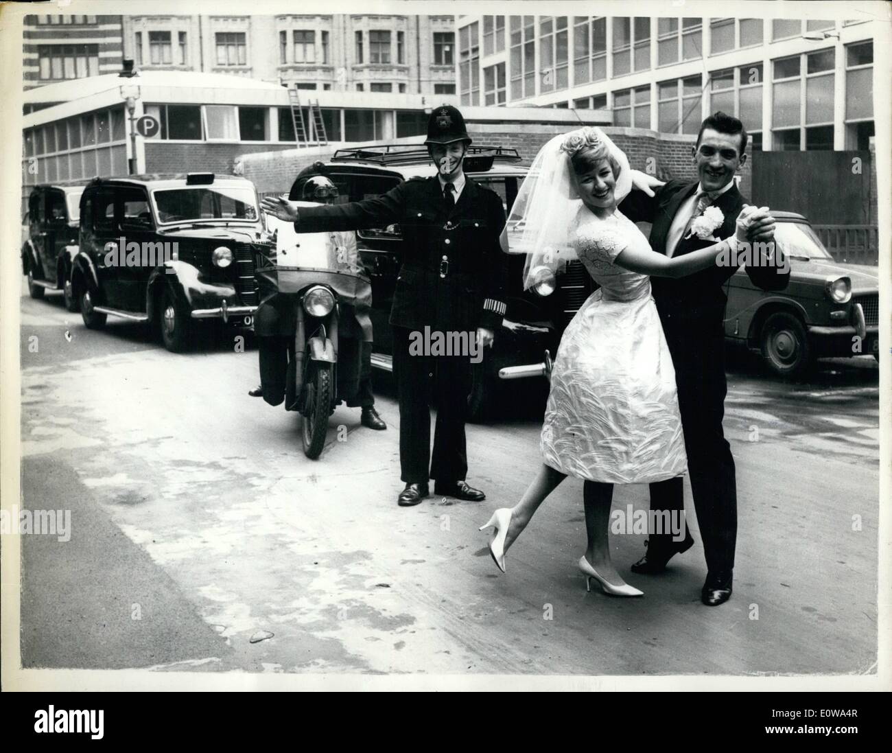 Apr. 04, 1962 - Dance Champions marry today: The marriage of John Donaldson, 29 and Sylvia Dearden, 27, the amateur ballroom champions of Essex, took place today at Caxton Hall, London. Photo shows a policeman holds up traffic an the couple dance across Caxton street in London after the wedding today. Stock Photo