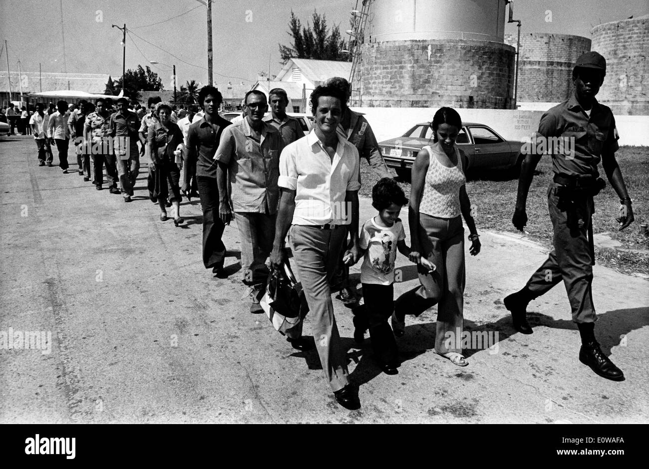 Official leads newly arrived Cuban refugees to camp Stock Photo