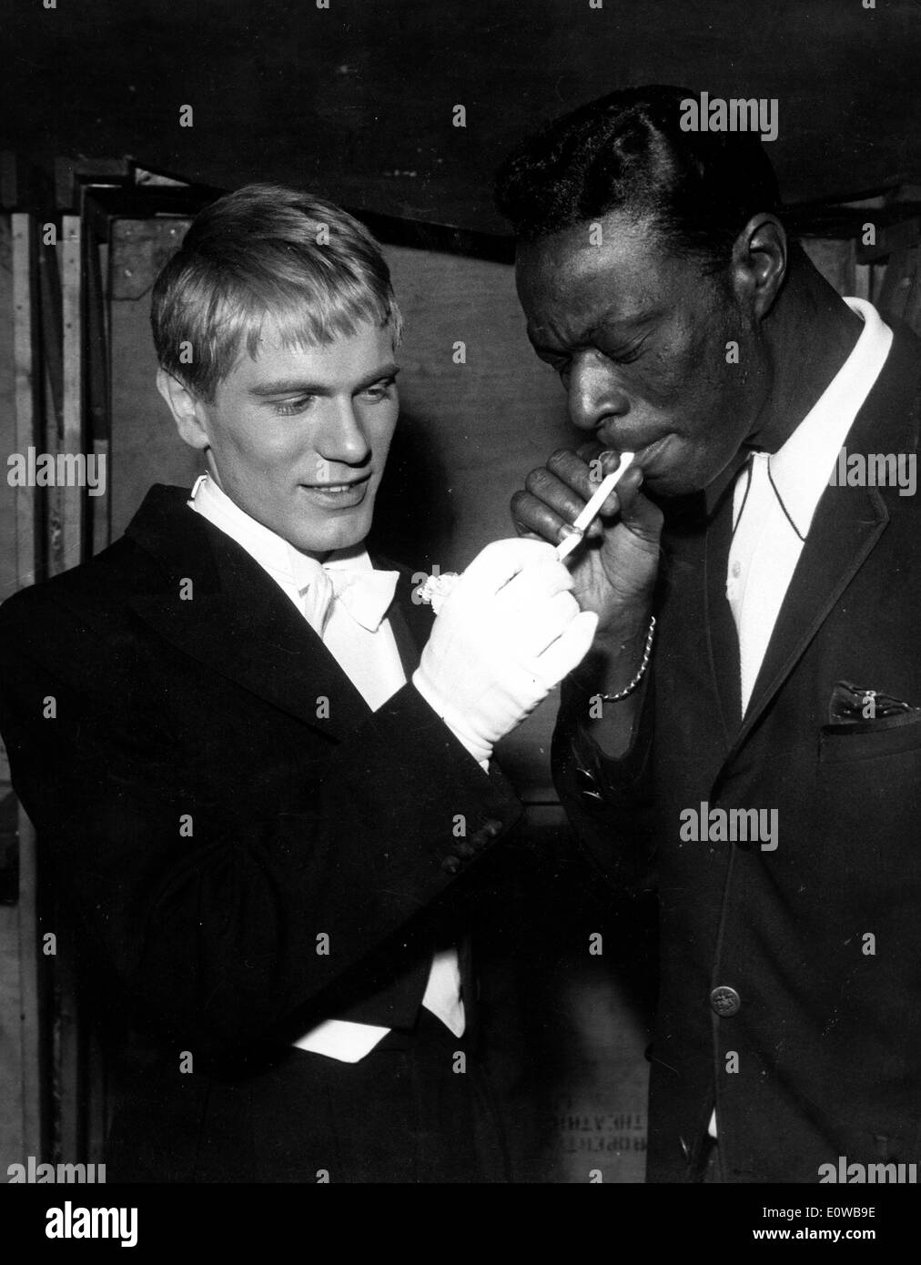 Musician Nat King Cole getting his cigarette lit Stock Photo
