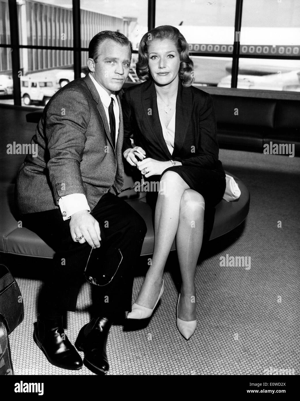 Gary Crosby sitting in the airport with a woman Stock Photo