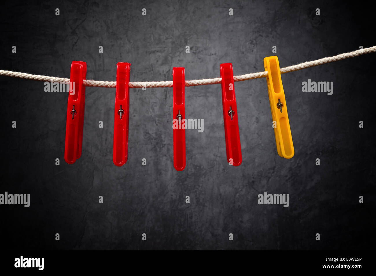 Clothes pins on the rope. Standing out from the crowd. Stock Photo