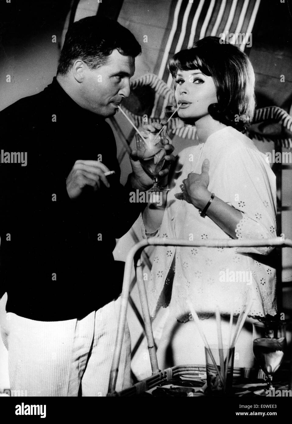 Actress Senta Berger and co-star Helmut Schmid having a drink on set Stock Photo