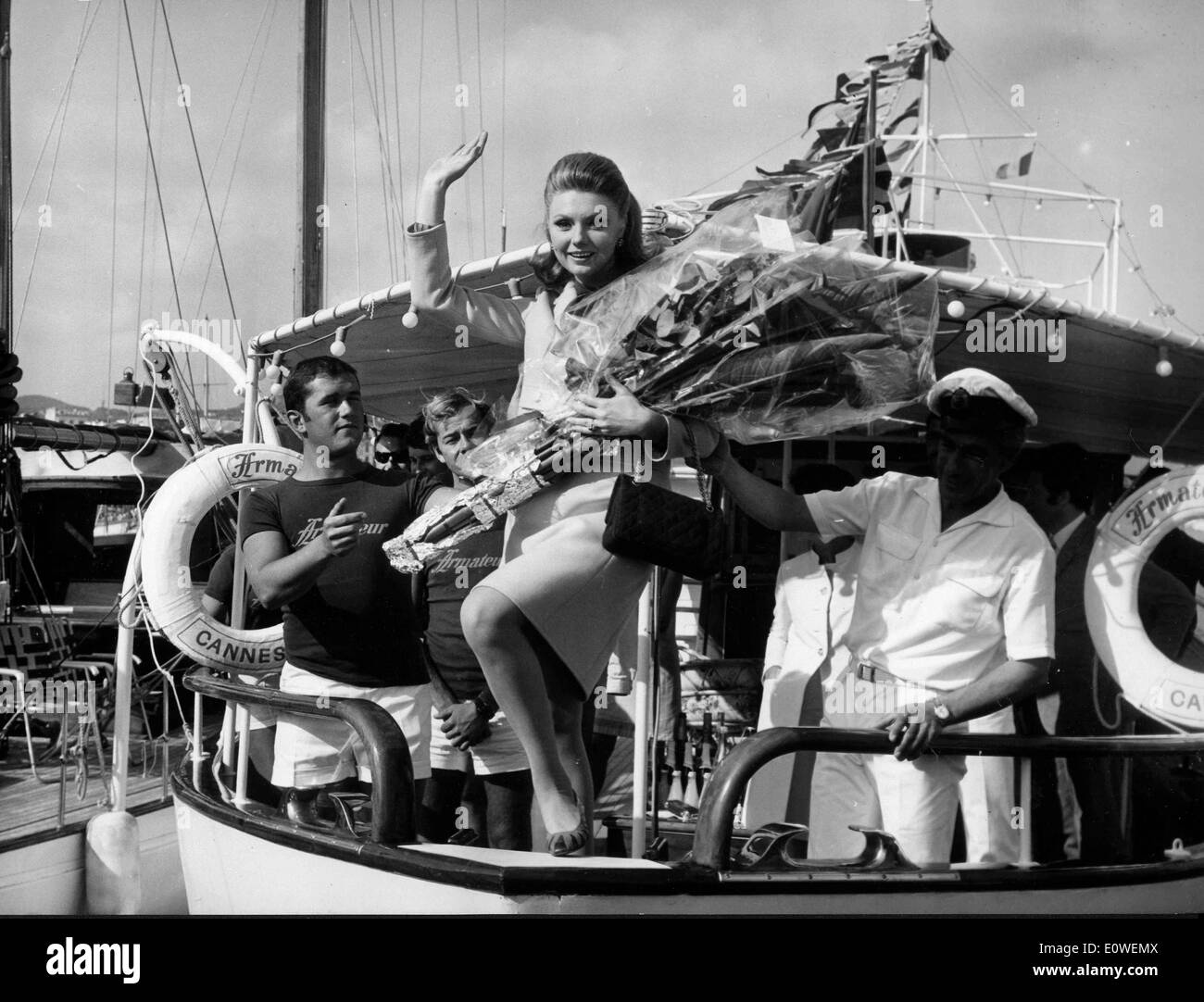 Actress Sylva Koscina waving with flowers from a boat Stock Photo