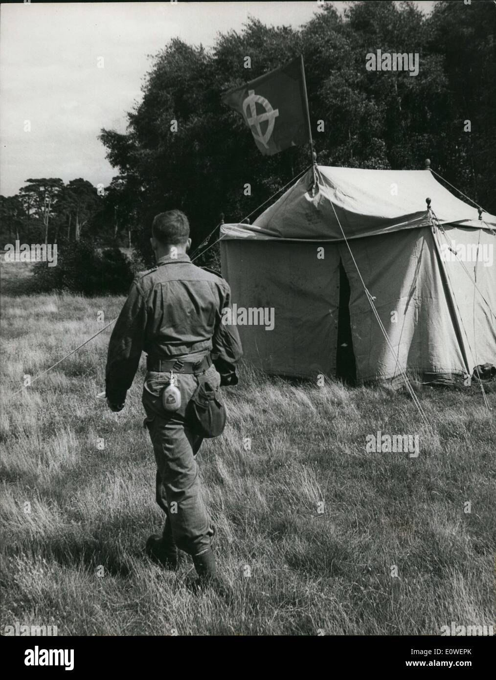 Aug. 08, 1962 - British Nazis rally in 1962: Followers of the British national party (Noe-Nazis) were attending a camp on the 5,000 acre estate at new ford. near swaffha, Norfolk, belonging to their president. A red flag with a white caltic cross fluttered on a mast and everything had the look of a peaceful summer camp. But inside, members (among them German and Italians) wave learning how to deal with anti-fascists when they hold their rally in Trafalgar so, next month. Photo shows a member in paratrooper uniform, walks past a tent with the movement flag. Stock Photo