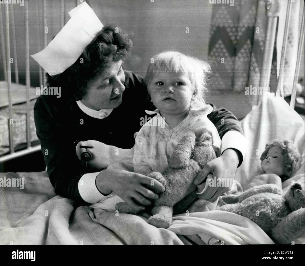 Oct. 10, 1962 - Girl lives after falling beneath a train.: Eighteen-month-old Anne Herbertson had a miracle escape from death beneath the wheels of a train on a level crossing at Usworth, Co. Durham. She and two-year-old playmate Audrey Laing were playing on the crossing when the diesel freight brain bore down o them, brakes jammed and hooter blowing. Mrs.Margaret Henderson, 61, ran from the door of her home 20 yards from the crossing and managed to pull Audrey clear. But Anne fell beneath the wheels of the train Stock Photo