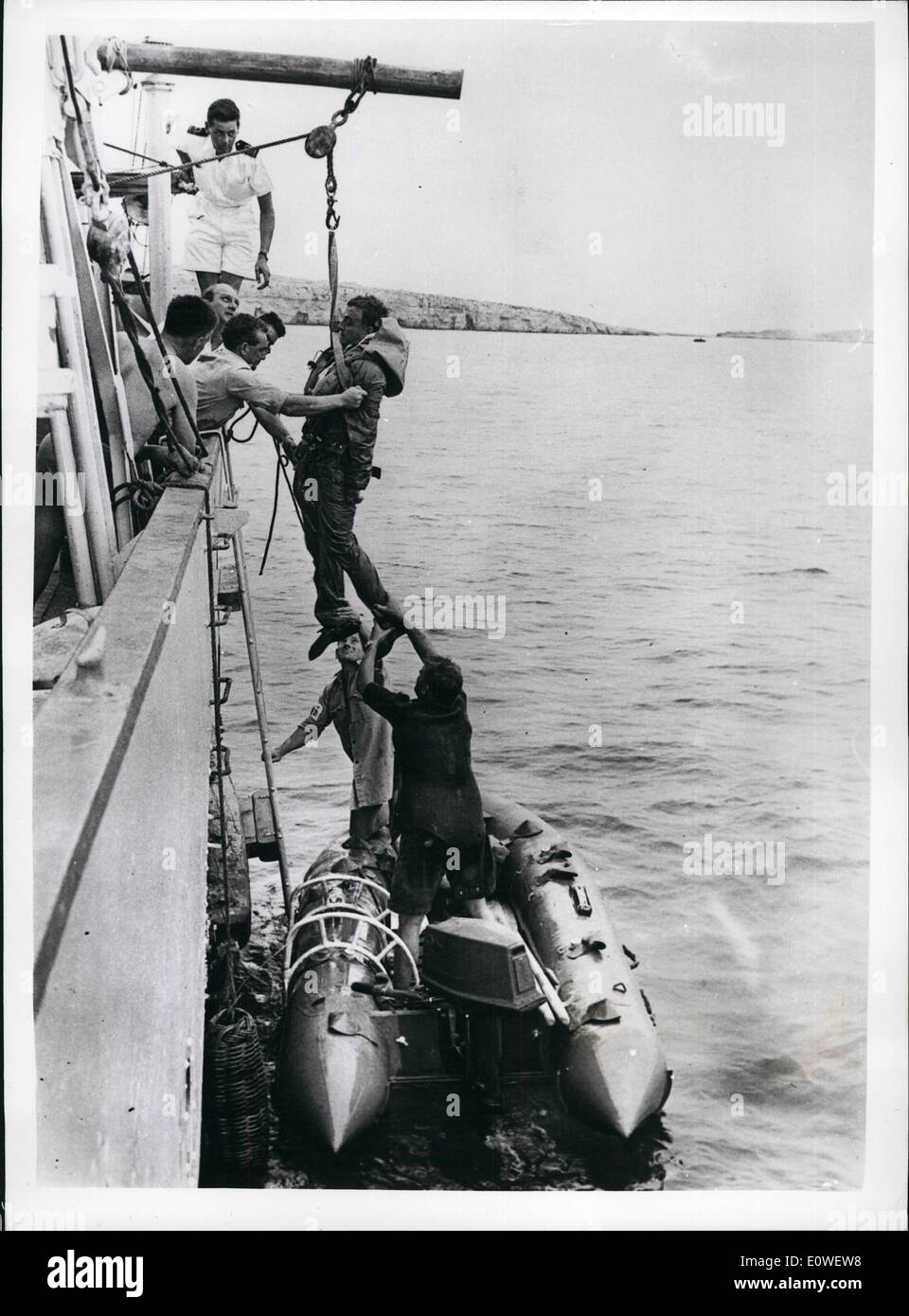Oct. 10, 1962 - Navy Men Escape From Submarine In experiment: Royal Navy men escaped from the submarine Tiptoe lying 260 feet down on the Mediterranean seabed and made history for the Navy: no R.N. man has ever survived an ascent to the surface from more than 150 feet before. The team experiment with new escape methods is from the submarine escape training school at Gosport, Hants. Photo shows Seconds after surfacing Petty Officer Leonard Stokes is hoisted to the deck of a ship for a physical check. Stock Photo