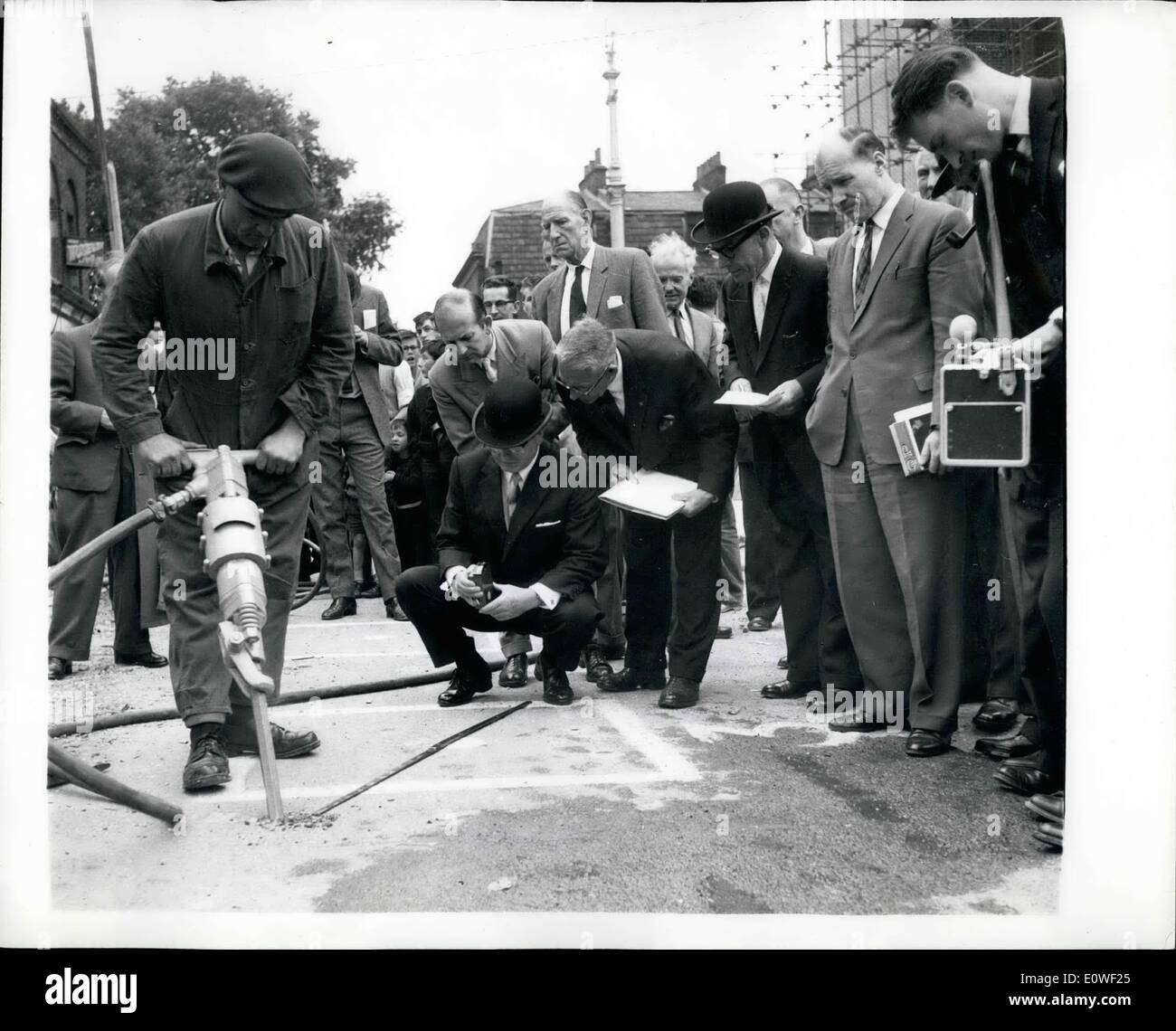 Aug. 08, 1962 - What Price Peace: Diamond Tipped Road Drills For London?: Bowler-hutted officials bend down on their haunches as they operate intricate guages to record the amount of noise produced by various types of road drills, in Shoreditoh, London, today. This is the Noise Abatement Society at work. A group of dedicated lovers of peace who are willing to pay any price for a bit of quiet in the capital city. No wonder the psychiatric couches are laiden with sufferes of nervous tension. Photo shows Mr.John Connell working a guage. The drill is pneumatic Stock Photo