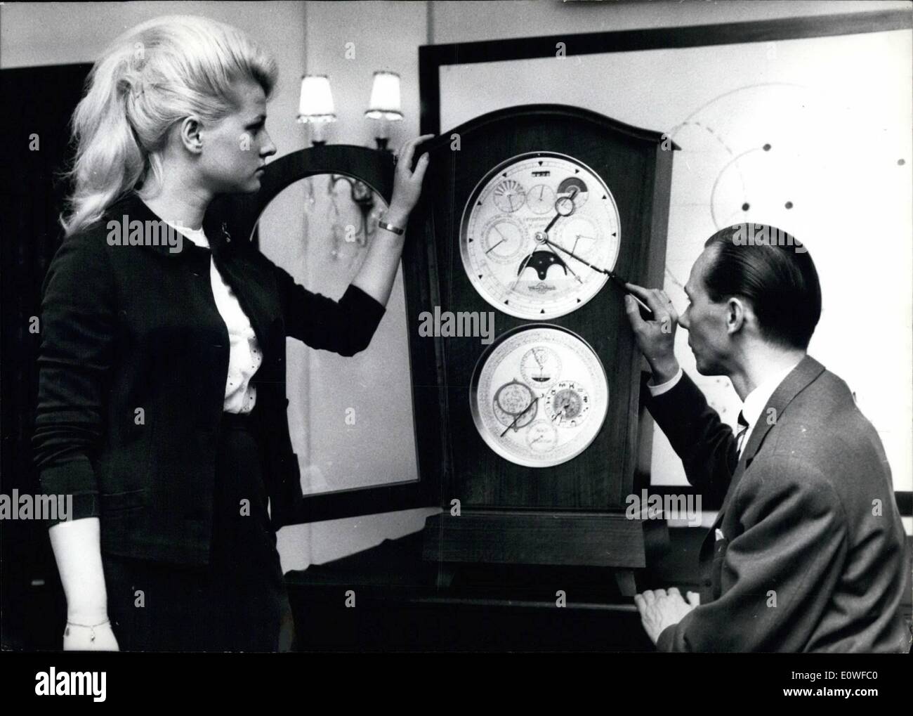 Aug. 08, 1962 - An astronomic watch with world calendar... has been built by watchmaker Hans Lang (right) from Essen Germany. He needed 3500 hours of work and about 30000 Marks to finish his work. Besides the normal time the 84 cm high watch holds dials for star time, gregorian calendar, world calendar as planned by UNESCO, sun, moon and other astronomic detauls. Lang srted his work in Dresden 1953. In 1958 he fled to western Germany, taking along the parts of the watch which was ready in 1961. Stock Photo