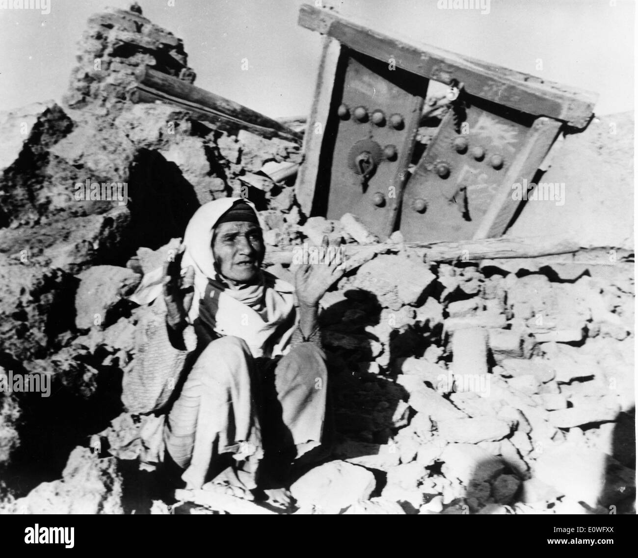 FILE PHOTO - Sep. 5, 1962 - Qazvin, Iran - A man seated on the rubble of his destroyed home near Tehran describes what happened Stock Photo