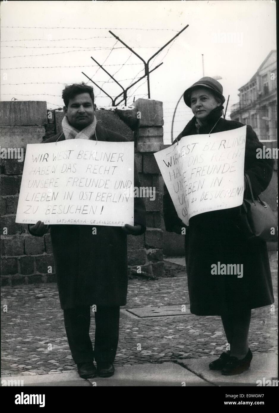 Dec. 12, 1962 - The right to see family and friends: on Wednesday (19.12) two Westberliner demonstraters stood by the wall in Chausseestrasse (Westberlin), to demonstrate against the East-Germany government line, in not letting people from the west visit friends and relations in the east. PHoto shows Nath Zutshi a chemical engineer on the left and a woman companion stand with plackards by the wall in Chausseestrassa today. Stock Photo
