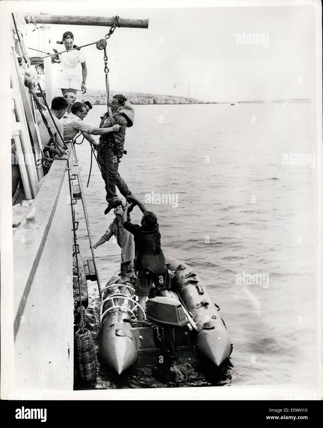 Oct. 04, 1962 - Navy Men Escape From Submarine In Experiment Royal Navy men escaped from the submarine Tiptoe lying 260 feet down on the Mediterranean seabed and made history for the Navy: no R.N. man has ever survived an ascent to the surface from more than 150 feet before. the team experimenting with new escape methods is from the submarine escape training school at Gosport, Hants. Photo Shows:- Seconds after surfacing Petty Officer Leonard Stokes is hoisted to the deck of a ship for a physical check. Stock Photo